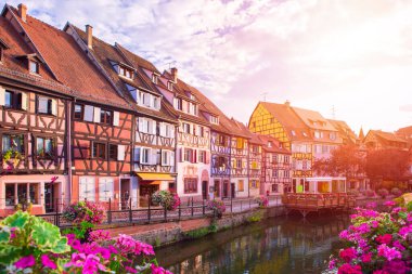 Colmar 'da günbatımı. Ünlü bir kent simgesi, çok renkli yarı ahşap evlere sahip romantik bir köy. Kanal kıyısında tanınmayan insanlar. Yaz zamanı, Alsace Fransa.
