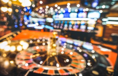 Blurred defocused background of roulette at casino saloon - Gambling concept with unfocused game room with video poker slot machines and multicolored blurry lights clipart