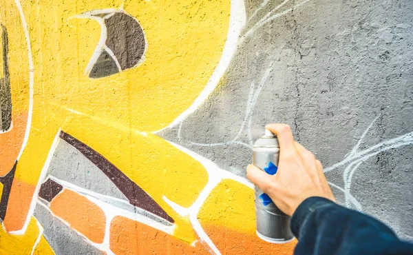 黄色のペンキに焦点を当てるとパブリックの壁 マルチ カラー スプレーとライブ題材を描く都市の男と現代アート コンセプト ビンテージ フィルターのカラフルな落書きを描くストリート アーティストの詳細 — ストック写真
