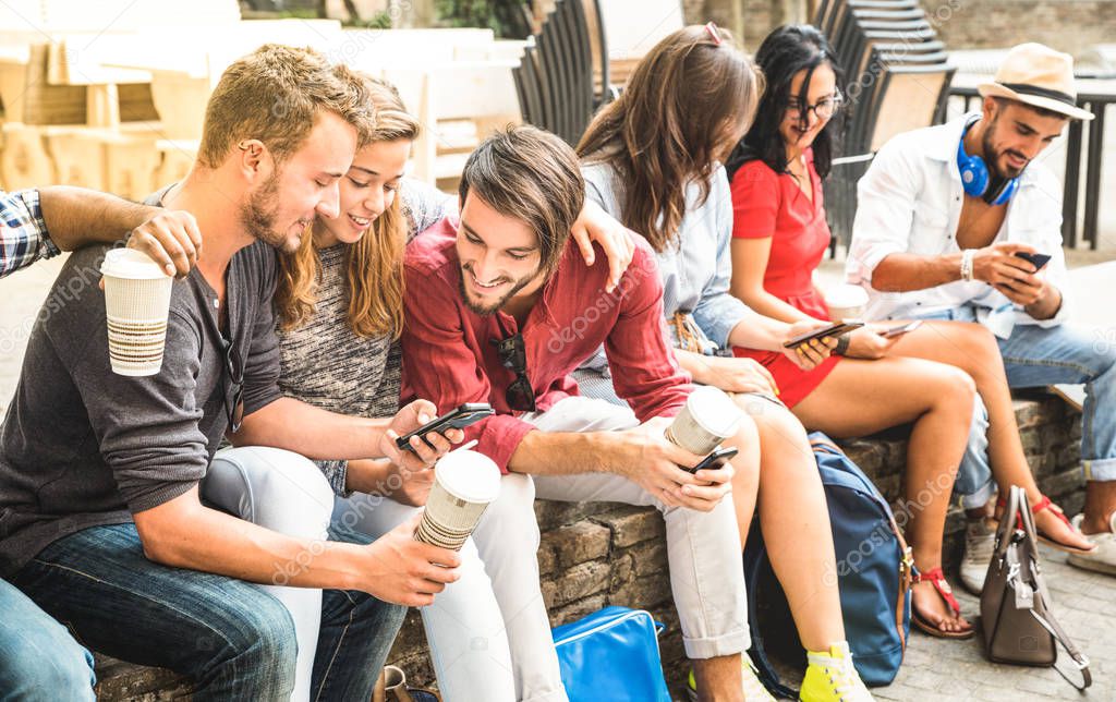 Multiracial millennials group using smart phone at city college backyard - Young people addicted by mobile smartphone - Technology concept with connected trendy friends - Warm vibrance sunshine filter