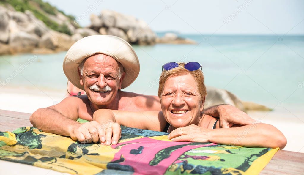 Senior couple vacationer having genuine fun on Koh Samui tropical beach in Thailand - Excursion tour in exotic scenario - Active elderly and travel concept around the world on warm bright sunny filter