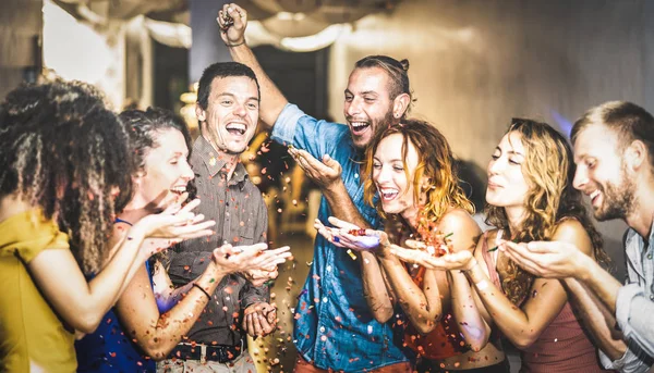 Multiracial happy friend having fun at new year's eve celebration - Young people blowing confetti at after party in night club - Friendship concept on cool entertainment mood - Focus on blue shirt guy