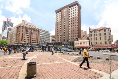 JOHANNESBURG, SOUTH AFRICA - NOVEMBER 13, 2014: everyday life at Gandhi square - After work in progress finished in 2002 the area got renovated bus terminal with 24 hour security and many new shops clipart