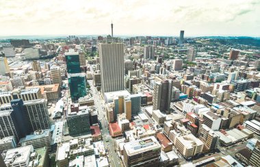 Aerial view of skyscrapers cityscape in business district of Johannesburg - Architecture concept with modern building skyline in South Africa big city - Landscape on desaturated dramatic filtered look clipart