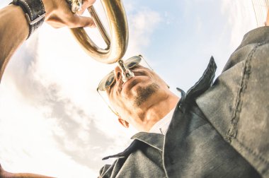 Sanatçı performans gösteren trompet solo caz karşı gökyüzü - müzik ve açık hava Kulübü yeri groove ruh atmosferi ile sokak sanatı kavramı - sıcak öğleden sonra renk tonları ile alt bakış açısı oluşturma