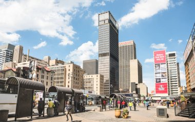 JOHANNESBURG, SOUTH AFRICA - NOVEMBER 13, 2014: everyday life at Gandhi square - After work in progress finished in 2002 the area got full operative bus terminal with 24 hour security and new shops clipart