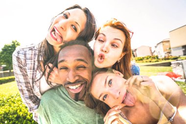 Happy multiracial friends group taking selfie sticking tongue out with funny faces - Young people sharing stories on social network community - Millennials lifestyle concept on vivid vintage filter clipart