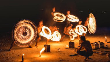 Group of firestarter performing amazing fire show with sparkles at night - Full moon party event festival in Thailand nightlife at beach resort - Wanderlust and travel concept around the world clipart