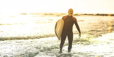 Adam sörfçü Tenerife - Surf uzun tahta eğitim uygulayıcı eylem - spor seyahat konsepti ile arka ışık - sıcak güneş renk nedeniyle yumuşak odak günbatımında sörf ile yürüme sesleri filtre