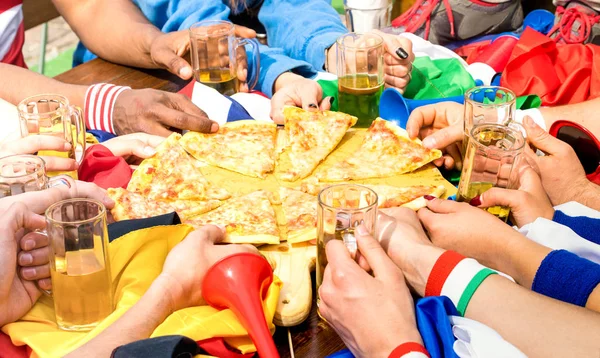 Top side view of multiracial hands of football friends supporter sharing pizza margherita at restaurant - Friendship concept with soccer fan enjoying food together - People eating at sport bar pub