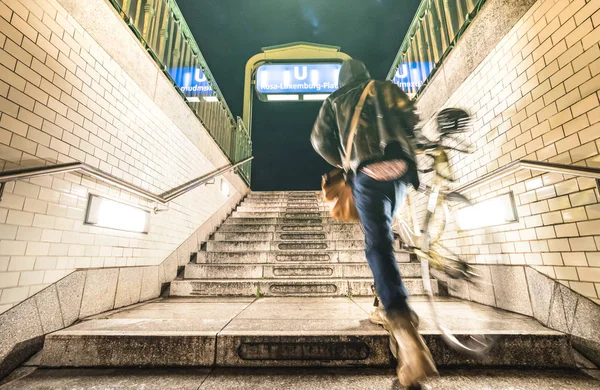 ベルリン 夜の地下の場所で通り男の都市生活旅行コンセプト グランジ コントラスト フィルターでローザ ルクセンブルク駅から自転車で多重男をぼやけ — ストック写真