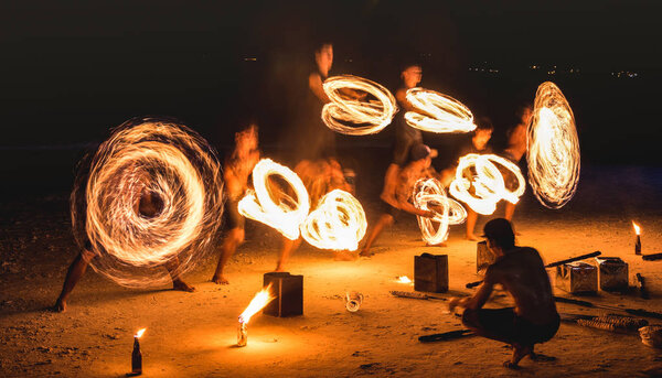 Group of firestarter performing amazing fire show with sparkles at night - Full moon party event festival in Thailand nightlife at beach resort - Wanderlust and travel concept around the world