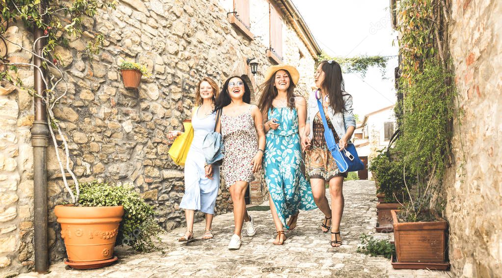 Multiracial millennial girlfriends walking in old town tour - Happy girl best friends having fun around city streets - University women students on travel vacations - Bright edsaturated vintage filter