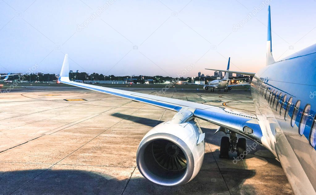 Airplane at terminal gate ready for takeoff at blue hour - Modern international airport with boarding aircraft on nighttime - Alternative lifestyle and wanderlust travel concept wandering around world