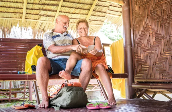 快乐的老夫妇使用手机在平房豪华度假村 积极的老年人和旅游概念总是连接到新的趋势和技术在世界各地的冒险之旅 温暖的过滤器 — 图库照片