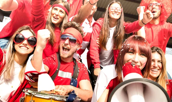地元のサッカー カップ スタジアム スポーツ世界選手権概念上で楽しい興奮を持つ赤の シャツを友人人グループで一致を見てフラグを若いアマチュア サッカー サポーター応援 — ストック写真