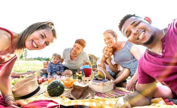 Glückliche multiethnische Familien machen Selfie bei Picknick-Gartenparty - multikulturelle Freude und Liebe Konzept mit gemischten Rassen Menschen Spaß zusammen beim Sonnenuntergang Picknick Grillen - warmer, lebendiger Sonnenscheinfilter — Stockfoto
