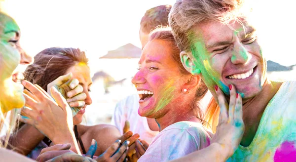Glada vänner att ha kul på stranden fest på holi färger festival event - unga människor skrattar tillsammans med uppriktig glada humör på sommarlovet - ungdom vänskap koncept på levande kontrast filter — Stockfoto