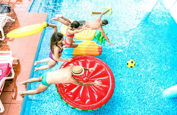 Hög vinkel syn på millenial vänner hoppa på poolen part - ungdom semester koncept med glada killar och tjejer att ha kul i sommardag på luxury resort - ungdomar på varma ljusa filter — Stockfoto
