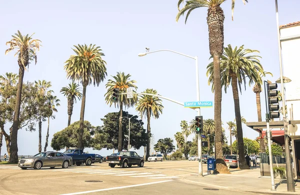 SANTA MONICA, EE.UU. - 20 DE MARZO DE 2015: tráfico diario con coches en la calle en la esquina entre Broadway Road y Ocean Ave en la costa cerca de Los Ángeles en el estado de California - Filtro caliente —  Fotos de Stock