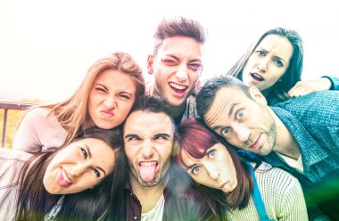 Komik yüzlerle selfie çeken çok kültürlü bin yıllık arkadaşlar - Dil dışarı ile birlikte eğlenen bin yıllık genç trendy insanlar ile mutlu gençlik dostluk konsepti - Parlak çok renkli filtre