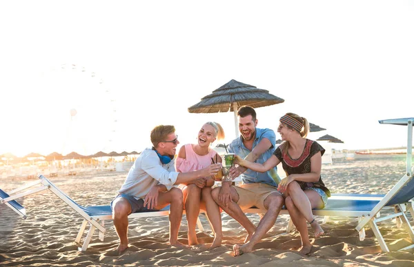 Fröhliche Millenial-Friends-Gruppe, die Spaß bei Strandparty hat und ausgefallene Cocktails bei Sonnenuntergang trinkt - Sommerfreude und Freundschaftskonzept mit jungen Leuten im Urlaub - warmer Sonnenschein gefilterte Farbtöne — Stockfoto