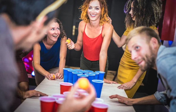 Young friends playing beer pong at youth hostel - Free time travel concept with backpackers having unplugged fun at guesthouse - Happy people on playful genuine attitude - Vivid vignetting filter — Stock Photo, Image