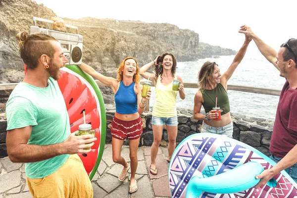 Jovens amigos de férias se divertindo na piscina natural no local de viagem - Happy millenial people dancing and drinking cocktails at alternative beach party - Wanderlust lifestyle concept on warm filter — Fotografia de Stock