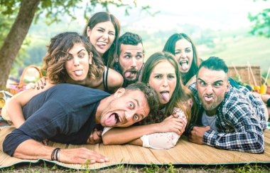 Pic nic barbekü de komik yüzleri ile selfie alarak Bin yıllık arkadaşlar - Dil dışarı ile birlikte eğlenmek bin yıllık gençler ile mutlu gençlik dostluk konsepti - Parlak yeşil masmavi filtre