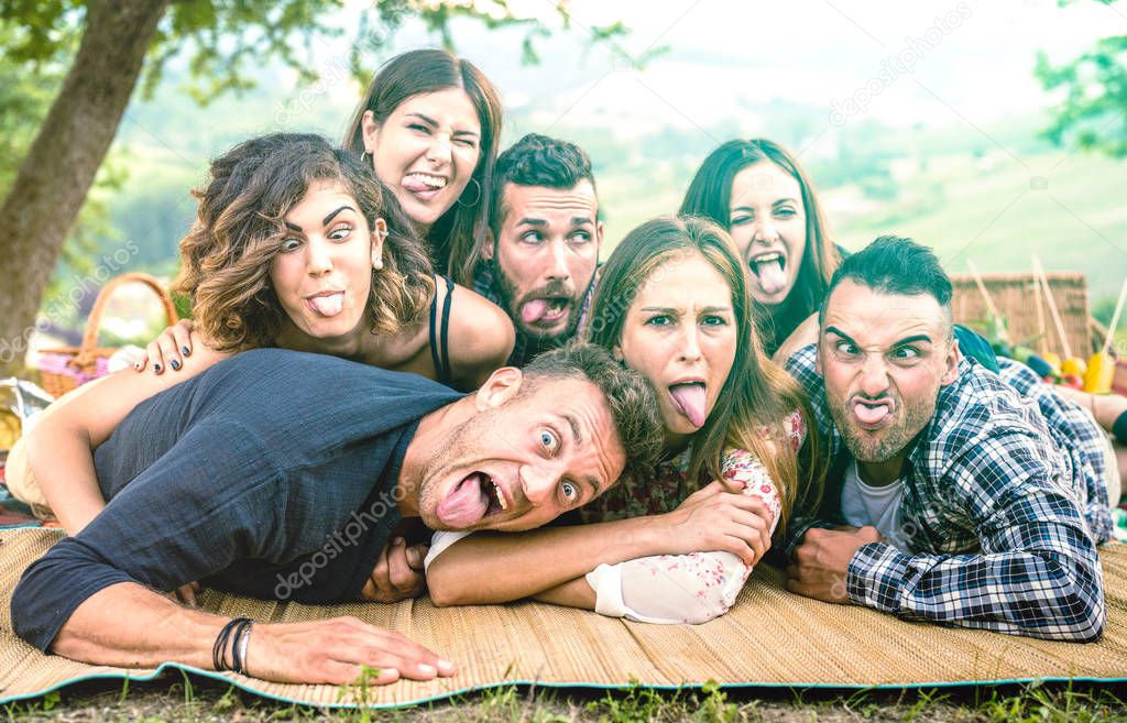 Millenial friends taking selfie with funny faces at pic nic barbecue - Happy youth friendship concept with millennial young people having fun together with tongue out -  Bright green azure filter