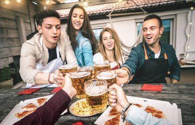 İş çıkışı evde pizza yiyen genç arkadaşların bakış açısı - Mutlu insanların birlikte eğlendiği ve bira bardakları içerek eğlendiği arkadaşlık konsepti - bira bardaklarına odaklan