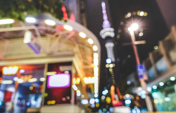 Vista borrosa y desenfocada del paisaje nocturno urbano en el centro de la ciudad de Auckland, capital de Nueva Zelanda - Fondo bokeh abstracto por la noche con luces brillantes y edificios borrosos - Filtro de colores vívidos —  Fotos de Stock