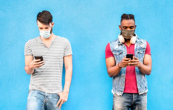 stock image Multiracial male friends with face masks using tracking app with mobile smart phones - Young millenial people watching updates on social media networks - New normal lifestyle concept on bright filter