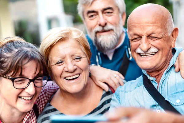 快乐的老朋友在老城区街道上自娱自乐 退休的人与手机一起玩乐 积极的老年生活方式理念 关注金发女人 — 图库照片