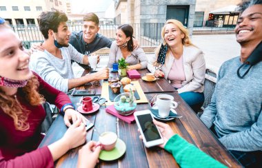 Arkadaşlar kafede cappuccino içerken eğleniyorlar - Restoran kafeteryasında gençler birlikte konuşuyor - Kafe barında mutlu erkekler ve kızlarla yeni normal yaşam tarzı konsepti - parlak canlı filtre
