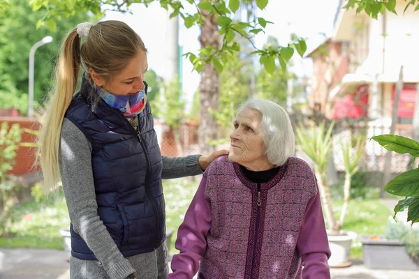 Mujer atractiva joven abrazando a la abuela al aire libre. Mujer - generaciones - amor — Foto de Stock