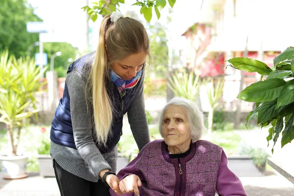 Mujer atractiva joven abrazando a la abuela al aire libre. Mujer - generaciones - amor — Foto de Stock