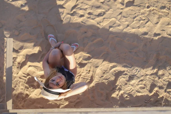 Портрет красивой загорелой сексуальной девушки на пляже. Женщина отдыхает в купальнике на песке. Концепция летних каникул — стоковое фото