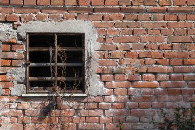 Eski bir tuğla duvar. Kırmızı tuğlaların arka planı. Eski demir pencereli tuğla duvar dokusu