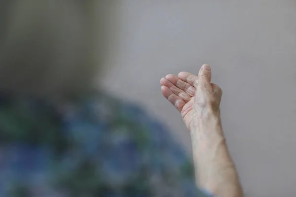 Пожилая женщина, морщинистая ладонь. Рука старушки. Пожилая дама ждет помощи. Концепция пожилых людей с легким фоном . — стоковое фото