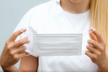 Talimatlar, tıbbi koruyucu maske takmak. Kız tıbbi maske takıyor..