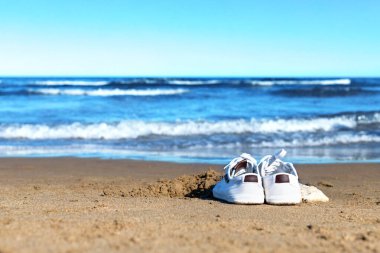 Spor ayakkabılar kumda. Kumsalda tek başına. Coronavirüslü tatil.
