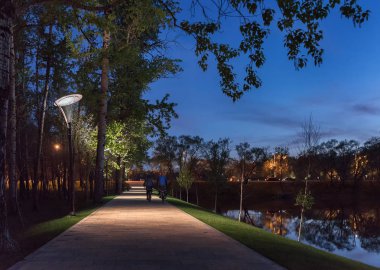 Gece manzarası. Moskova. Meshchersky gölet yolda. Onların Bisiklet Park yol boyunca iki bicyclists binmek