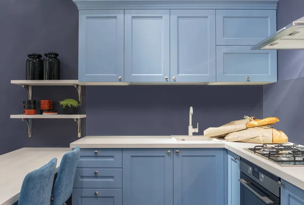 Cocina moderna de madera al estilo Loft. Muebles azules con mesa blanca, fregadero y estufa de gas — Foto de Stock