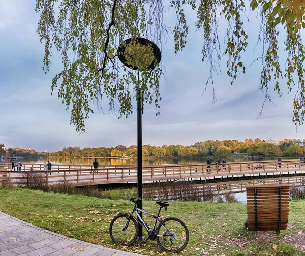 Moskwa. 14 października 2018. Strefa relaksu w parku Meshchersky. Ludzie chodzą po drewnianym moście nad stawem i podziwiają piękną jesienną scenerią — Zdjęcie stockowe