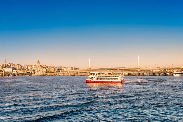 Turkey. Istanbul. July 06, 2019. Excursion motor ship goes along the Golden Horn bay against the background of the Metro Bridge at sunset — Stock Photo, Image