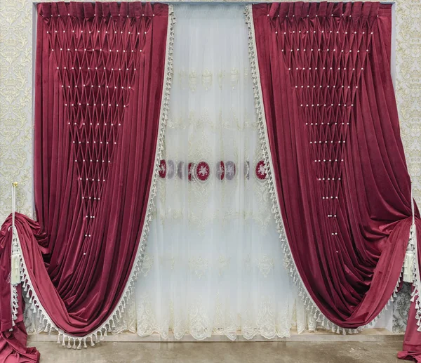 Красные бархатные занавески с помпонами и белый тюль с вышивкой. Интерьер в стиле дворца — стоковое фото