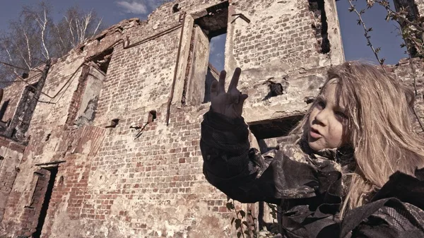 描绘孤独肮脏的无家可归的女孩指着废弃的建筑 — 图库照片