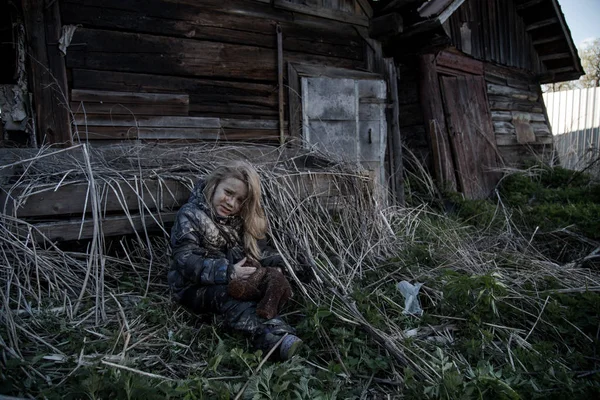 放棄された建物が泣いている横にある孤独な汚いホームレス少女の肖像画 — ストック写真