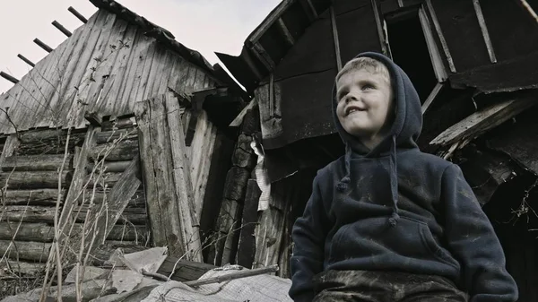 无家可归的孤儿坐在废弃的建筑旁边 — 图库照片